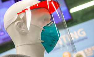 Mannequin wearing a teal face mask and clear face shield