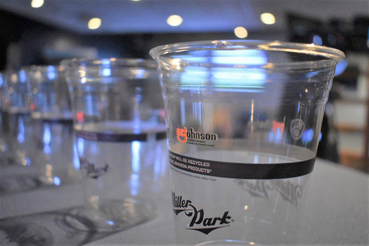 Clear plastic cup labeled Johnson and Miller Park on a bar counter, with other cups in the background