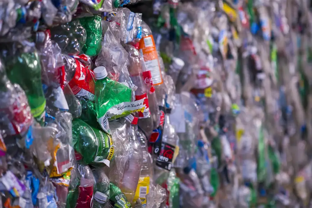 Wall of compressed plastic bottles and containers, illustrating the volume of plastic waste