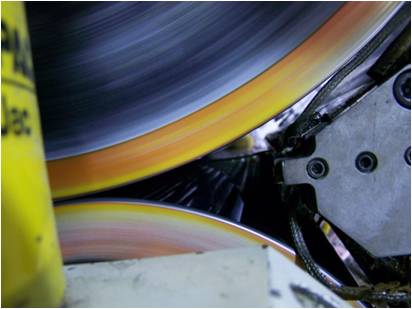 Close-up of colorful rotating rollers and metal components inside industrial machinery