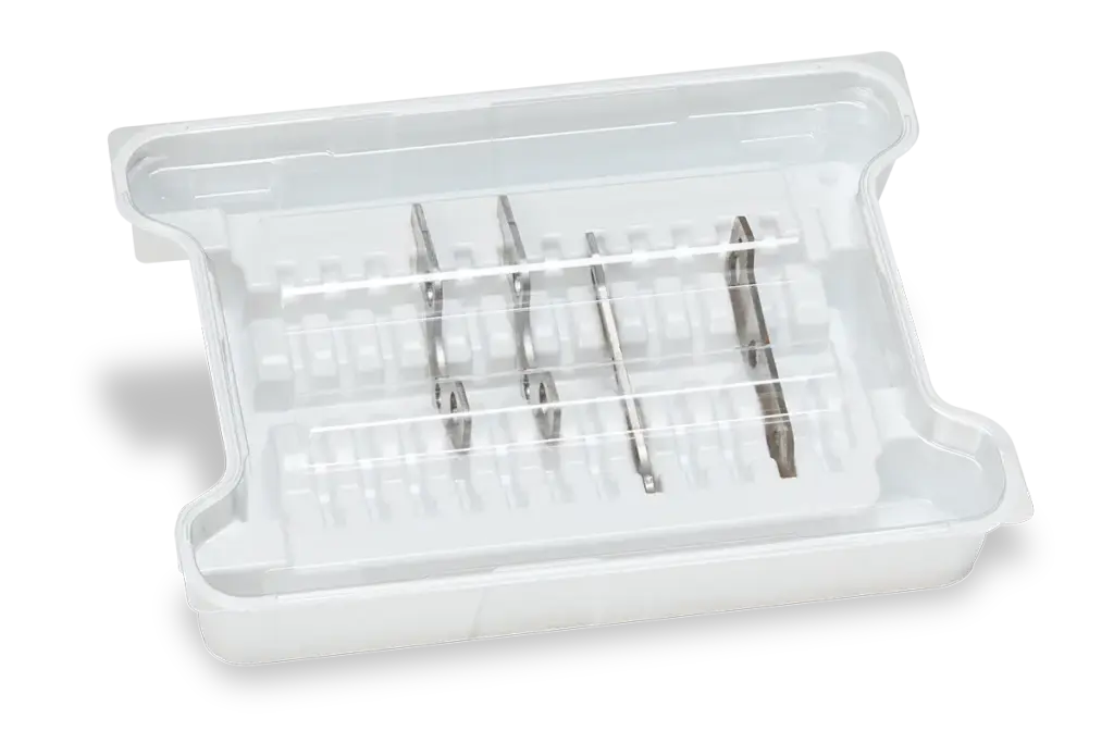 White plastic storage tray with a transparent lid and several metal cutting blades in molded compartments