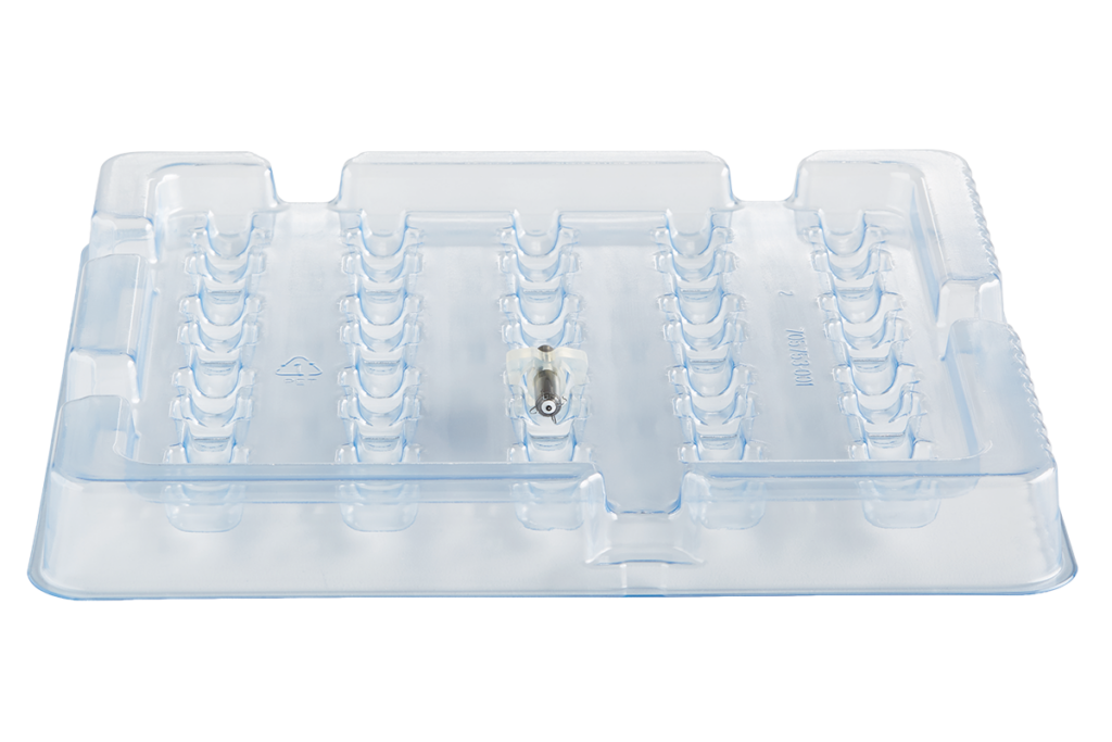 Transparent plastic tray with molded compartments and a small metal component in the center